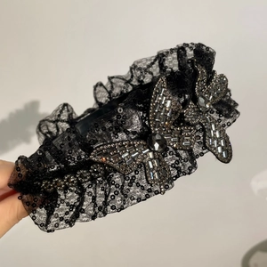 Détail d'un serre-tête en dentelle avec sequins et papillons en cristal scintillant