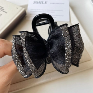 Detailed close-up of double-layer mesh bow hair claw clip with shimmering rhinestones