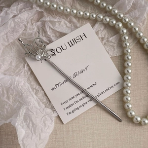 Detail of silver butterfly hair pin with pearls and rhinestones on a decorative card