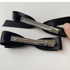 Elegant black bow hair clip with pearls and metal duckbill clip shown on white background