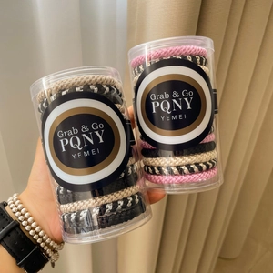 Detail of high-elasticity braided hair ties set in transparent cylindrical tube packaging
