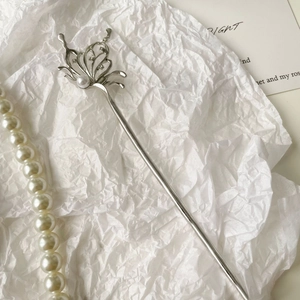 Detailed macro view of an elegant silver butterfly hair pin with a white pearl accent