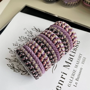 Detail view of colorful braided elastic hair ties set on display with aesthetic background