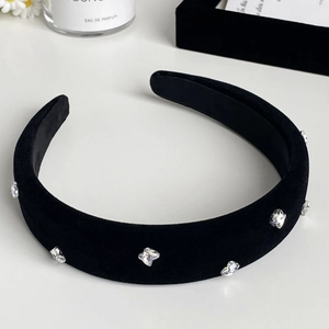 Macro shot of black velvet headband featuring sparkling rhinestones and plush texture