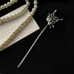 Detailed macro view of silver butterfly hair pin with pearls and zircon stones