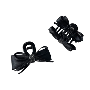 Elegant set of two black satin bow hair claws with sparkling rhinestones on white background
