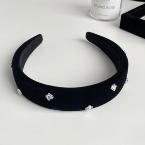 Detailed macro view of black velvet headband featuring sparkling crystal flower ornaments