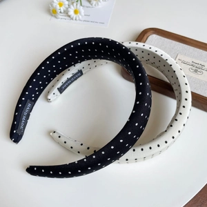 Detailed view of polka dot sponge headbands with a hand made woven label and fabric texture