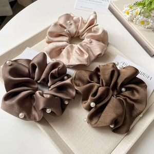 Elegant silk satin hair scrunchies with pearl embellishments in champagne and brown tones