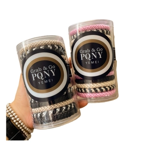 Elastic ponytail holders set in a clear cylinder package with various colors and textures