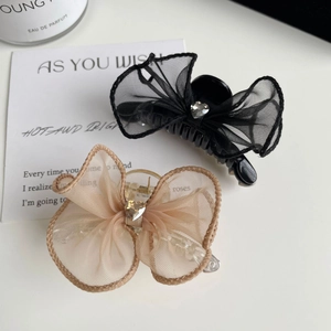 Détail de barrettes noeud en résille avec cristal en forme de coeur en champagne et noir