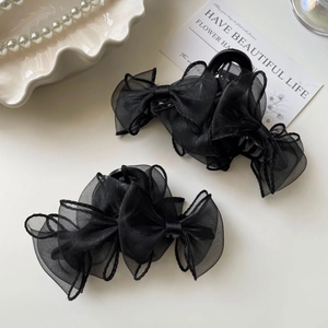 Détail des élégantes pinces à cheveux en organza noir avec nœuds pour coiffures de femmes