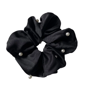 Elegant black satin hair scrunchie with white pearl accents and ruffled silk-like texture