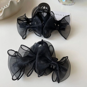 Élégantes pinces à cheveux noires avec nœud en organza pour femmes sur fond blanc épuré