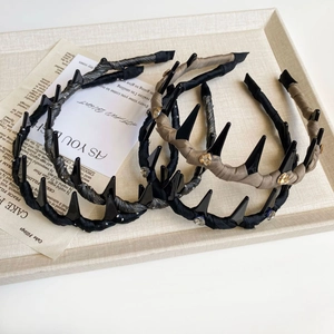 Detail of three wavy resin headbands featuring sparkling rhinestones and textured fabric wrap