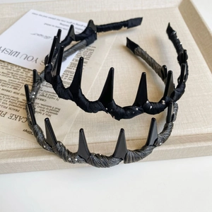 Detail of punk style headbands with black spikes and rhinestones on a textured tray