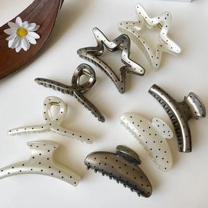 French polka dot hair claw set in star and crescent shapes on a minimal background