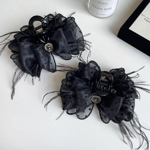 Elegant black polka dot mesh hair claw clip with feather detail and crystal center