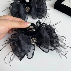 Detail of black polka dot mesh hair claw with feathers and vintage crystal inlay