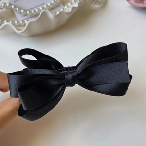 Vista dettagliata del fermaglio a fiocco in raso nero elegante con consistenza in seta