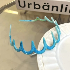 Vista dettagliata del cerchietto ondulato in resina con trama marmorizzata blu e denti di tenuta