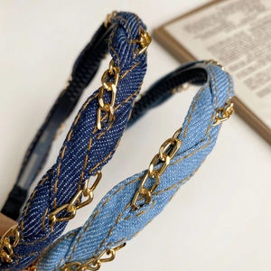 Close-up of woven denim fabric headband with gold chain details in blue and light blue