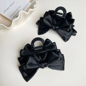 Elegante coppia di mollette per capelli con fiocco in raso nero e finitura opaca in stile minimal