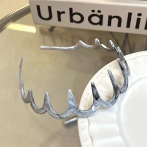 Dettaglio del cerchietto ondulato in resina con texture marmorea grigia e bianca su ceramica