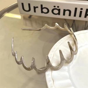 Dettaglio di cerchietto ondulato in resina con trama marmorea su piatto in ceramica