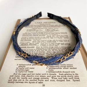 Detail of denim braided headband with gold metal chain accent and non-slip inner teeth