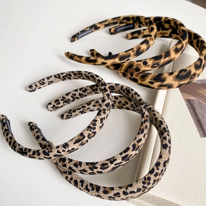 Detail of handmade leopard print fabric headbands featuring a woven handmade label