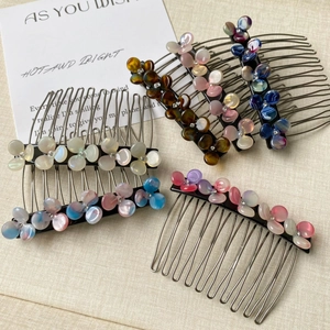 Close-up of four floral hair side combs in tortoiseshell and marble finishes