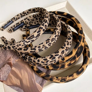 Vintage leopard print wide fabric headbands in brown and grey tones on a beige tray
