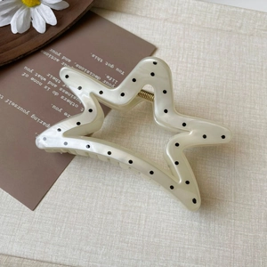 Star-shaped cream hair claw with black polka dots and gold spring detail