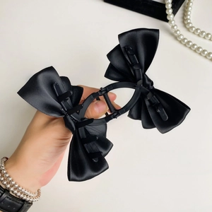 Grande molletta per capelli con fiocco di raso nero per donna su sfondo elegante