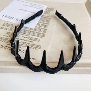 Detail of black gothic headband with pointed resin spikes and silver glitter accents