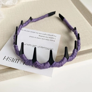 Détail d'un serre-tête en satin violet avec dents de peigne noires pour coiffure volumineuse