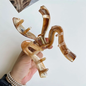 Détail d'une grande pince à cheveux à motif marbré et ressort en métal doré renforcé
