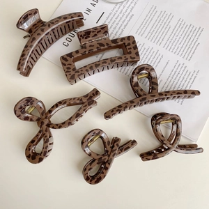 Five assorted leopard print hair claw clips in tortoiseshell resin with gold metal springs