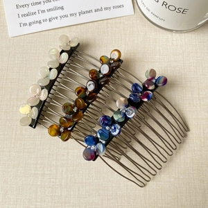 Detailed view of three floral hair side combs with pearls and rhinestones