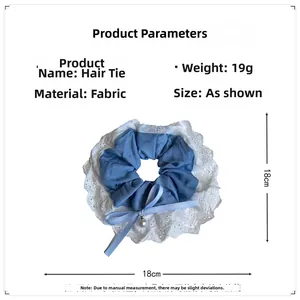Detail of blue denim hair scrunchie with white lace edge, silk bow and pearl pendant