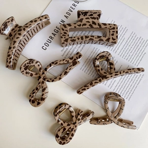Detailed close-up of leopard print and heart pattern hair claws set on a magazine background