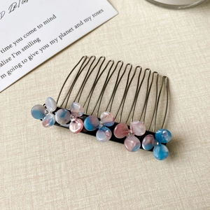 Close-up of 10-tooth metal hair comb with five gradient acetate flowers and rhinestones