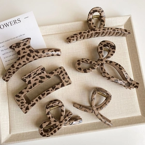 Close-up of assorted brown leopard print hair claws in various vintage bow and curved shapes