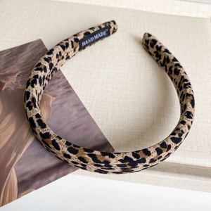 Detailed macro view of leopard print headband texture and internal handmade woven label