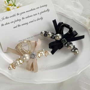 Détails de pinces à cheveux en satin avec perles et strass sur une assiette en céramique