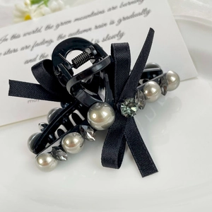 Vue détaillée de la pince à cheveux en satin noir avec perles grises et cristaux