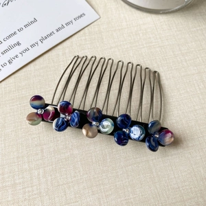 Macro view of floral hair comb with colorful resin petals and sparkling rhinestones