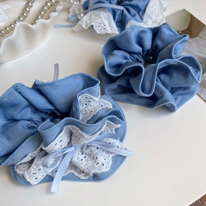 Close-up of blue denim scrunchies set with white lace trim and silky ribbon bows