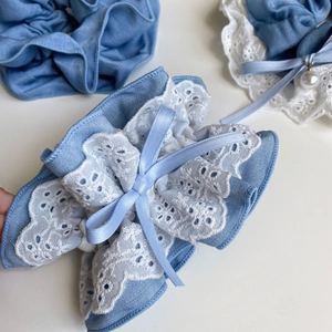 Detail of light blue tencel denim scrunchie with layered lace and faux pearl bow